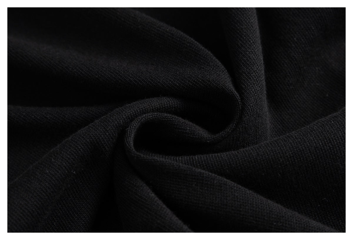 Close-up of black knit fabric draped in soft folds, showing its textured surface.