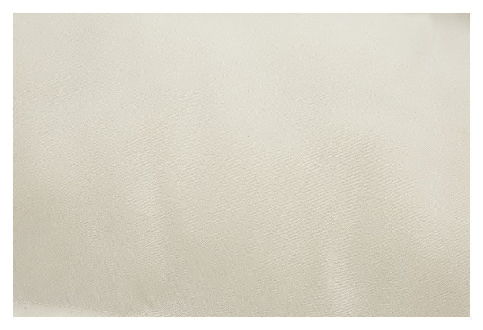 Close-up showing the subtle texture of plain cream fabric.