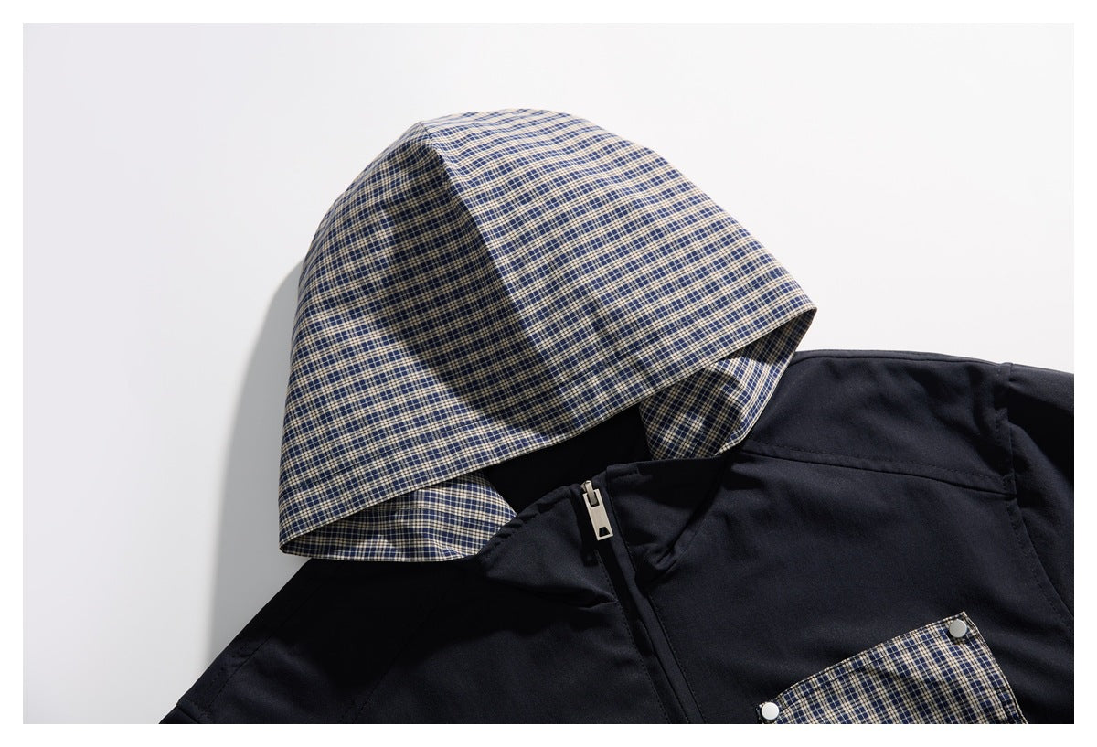 Close-up of a navy jacket's blue-and-beige plaid hood, zipper, and matching chest pocket.