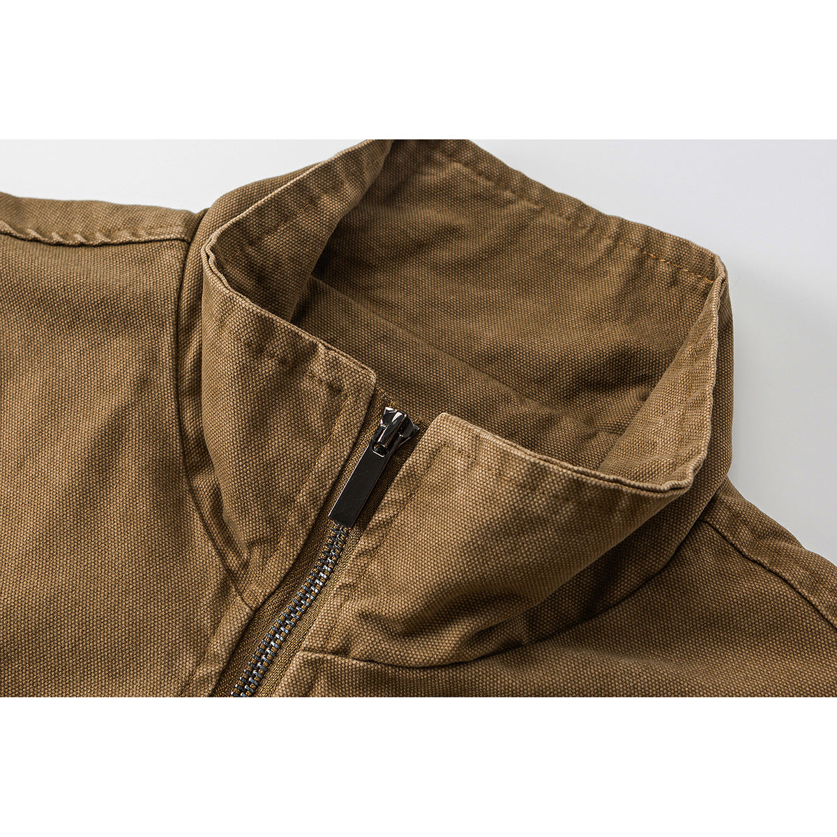Close-up of a brown textured jacket’s stand collar and front zipper.