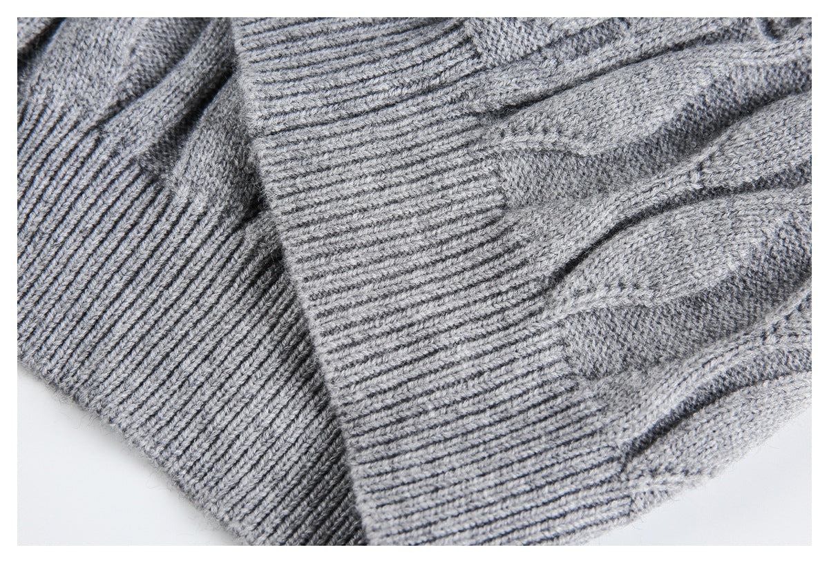 Close-up of overlapping ribbed edges and cable-knit fabric on a gray sweater.