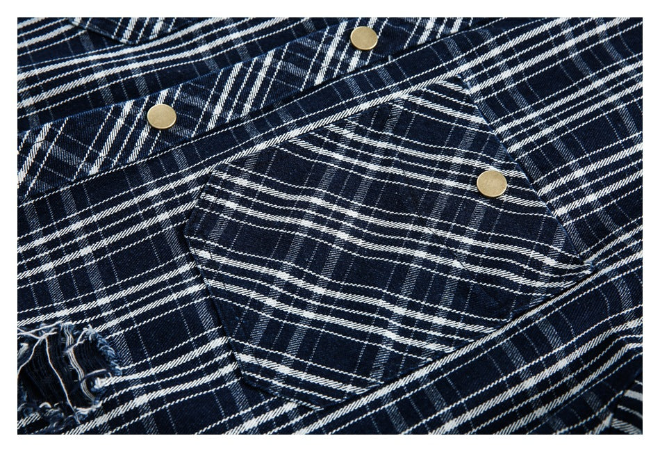 Close-up of a navy-and-white plaid shirt with a buttoned flap pocket and a frayed distressed opening.