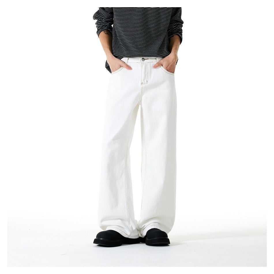 Front view of a model wearing white wide-leg pants with contrast stitching, a black striped top, and black shoes.