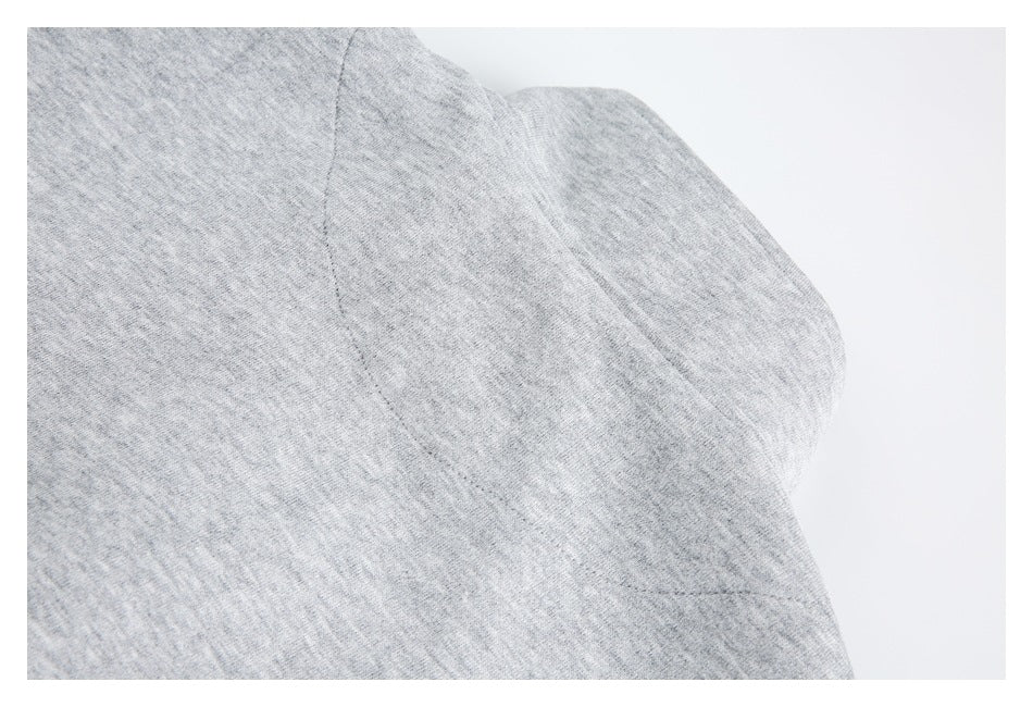 Close-up of the light gray sweatshirt's sleeve and body seam.
