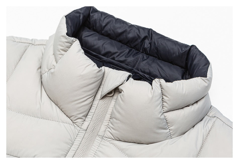 Close-up of the light gray jacket's zip front and padded stand collar with dark navy lining.