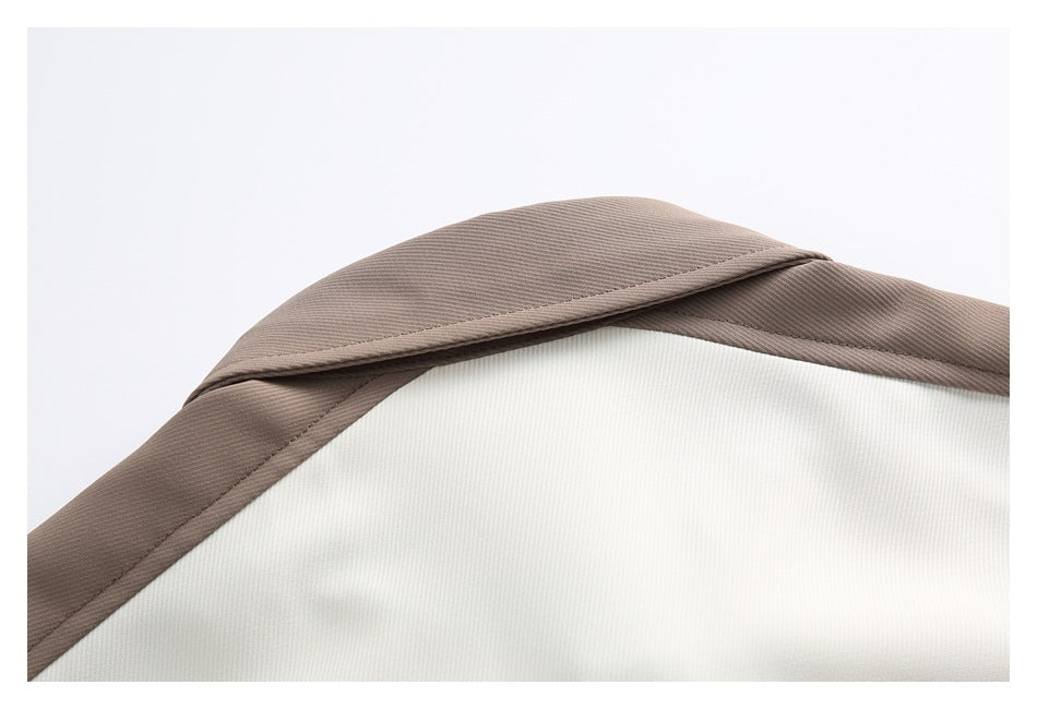 Close-up of the taupe collar and cream fabric of a shirt.