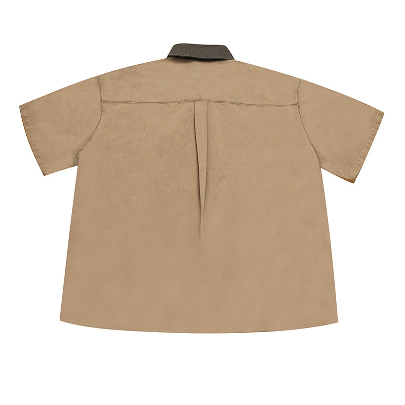 Back of khaki short-sleeve shirt showing yoke seam, center pleat and brown collar, flat lay