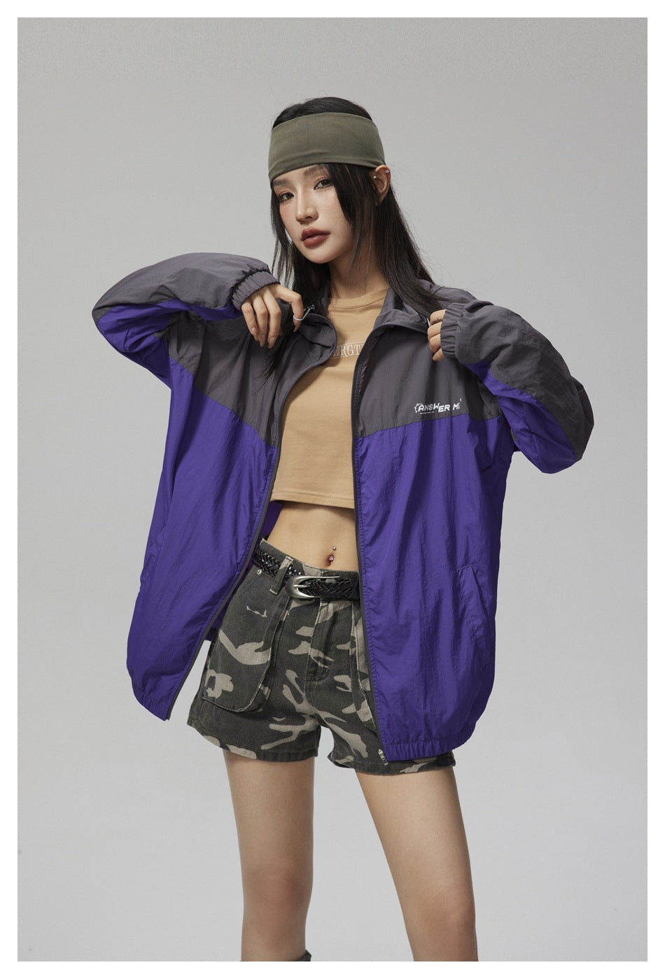 Model wearing an open purple and charcoal color-block hooded jacket with camouflage shorts.