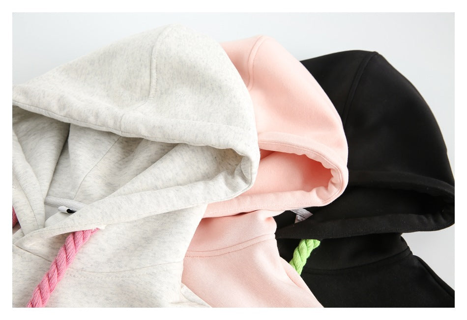 Close-up of the hoods and upper sections of light gray, pale pink and black hoodies.