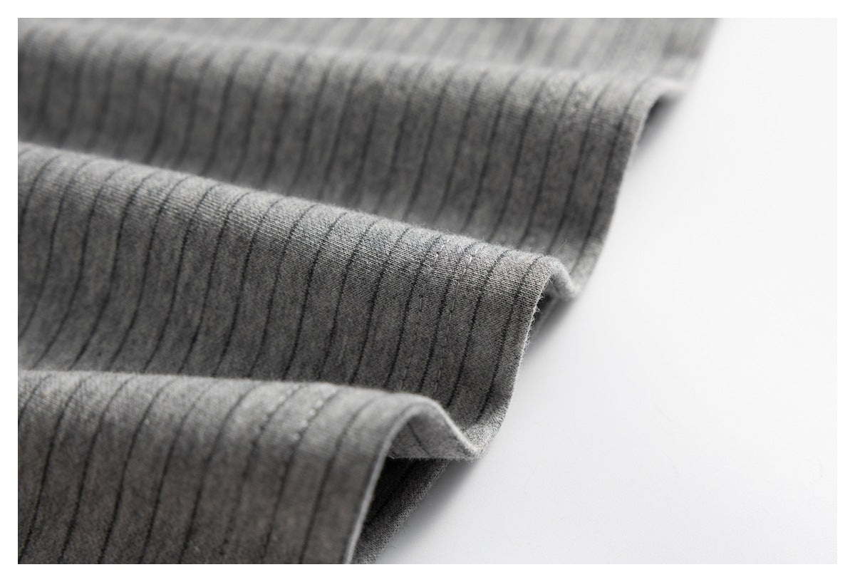 Close-up of gray pinstriped fabric arranged in soft folds, showing its edge and drape.