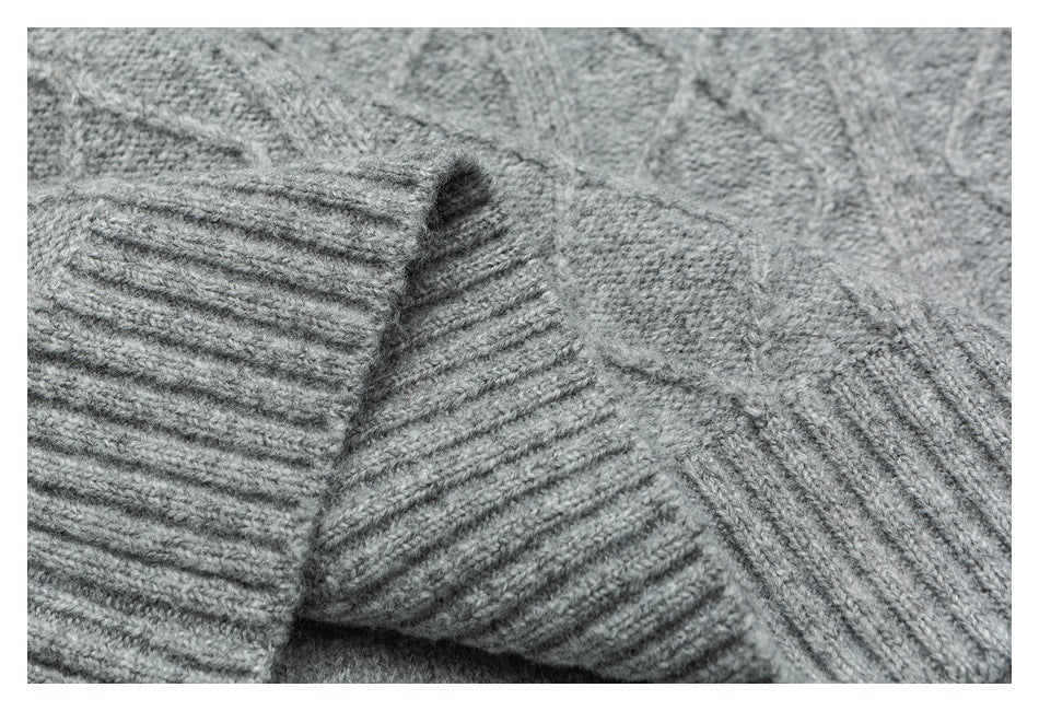 Close-up of a gray sweater sleeve cuff and knit seam construction.