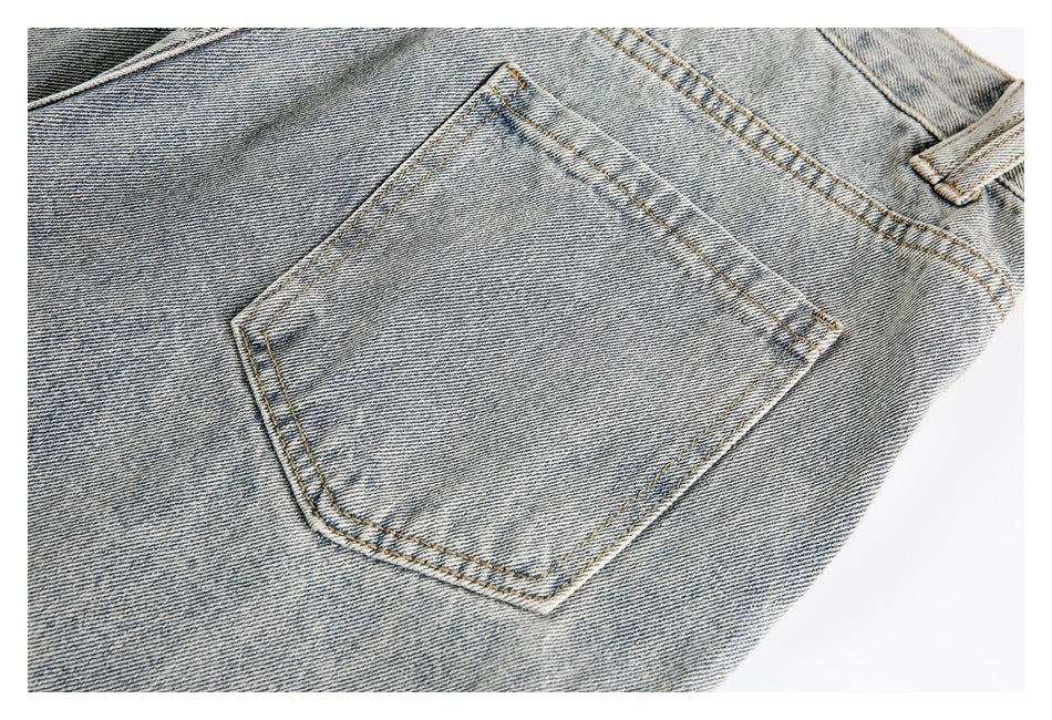Close-up of a light-wash denim back pocket with double stitching and a belt loop.