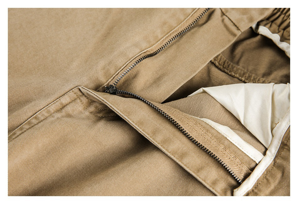 Close-up of tan pants with the zipper fly open, revealing light-colored inner fabric.