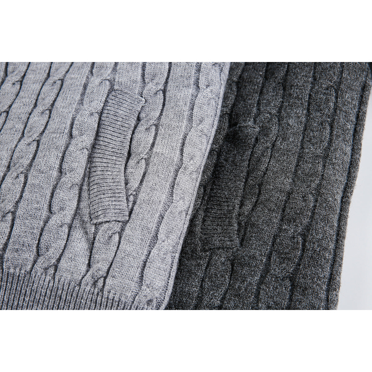 Close-up of light and dark gray cable-knit cardigan fabric and ribbed trim.