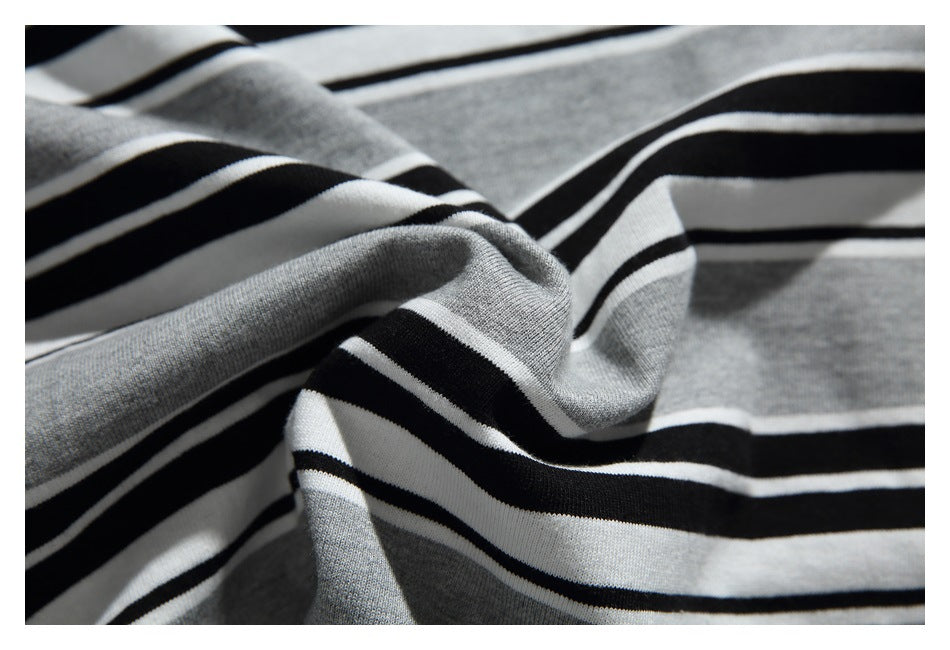 Close-up of gray, black, and white striped knit fabric gathered into soft folds.
