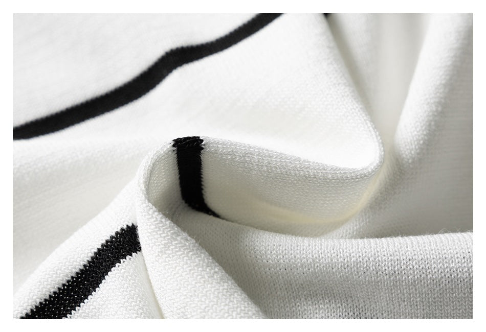 Close-up of folded white knit fabric with narrow black stripes.