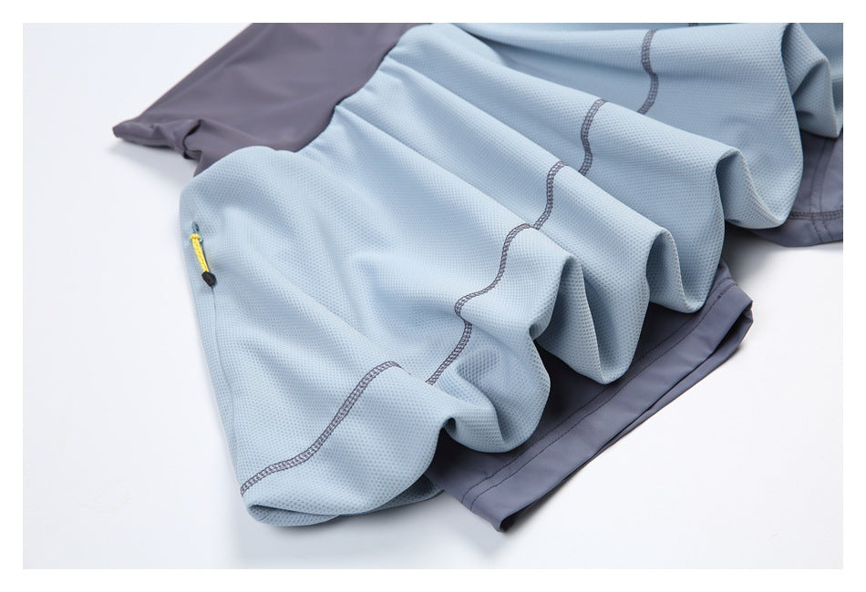 Close-up of the light blue skirt fabric, curved seam stitching, and yellow zipper pull over a slate-gray underlayer.