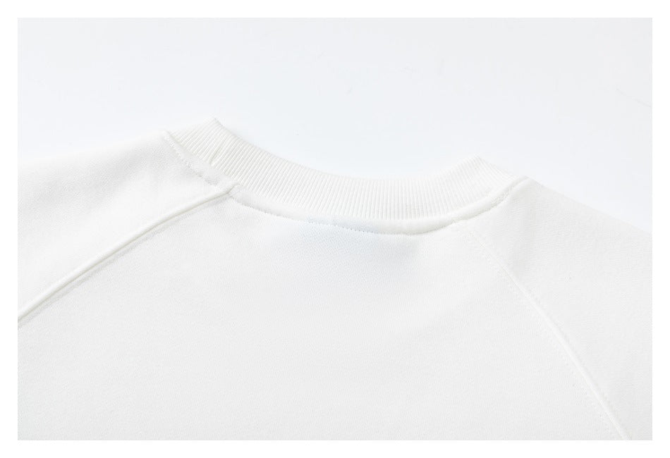 Close-up of the white sweatshirt's ribbed crew neckline and shoulder seams.