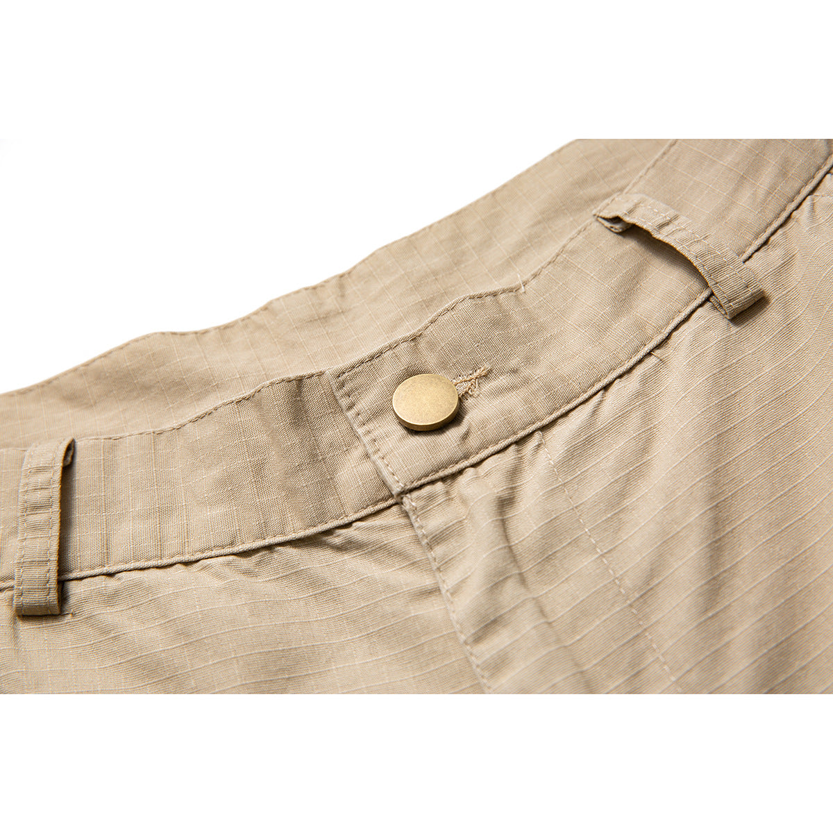 Close-up of tan shorts showing the waistband, belt loops, stitching, and round metal button.