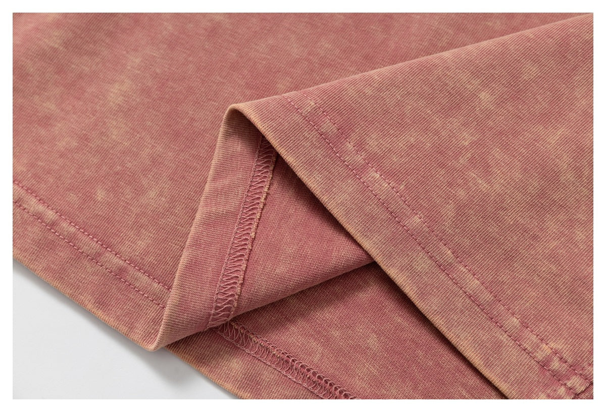 Close-up of a dusty pink garment hem folded back to show the inside stitching.