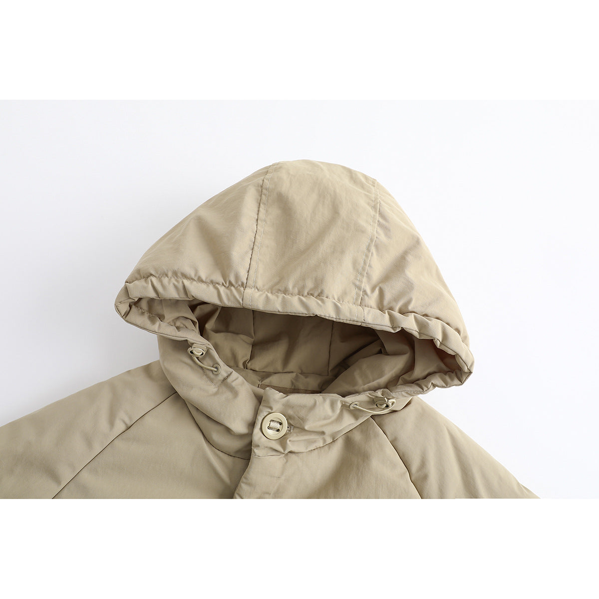 Close-up of a beige jacket’s large hood, gathered edge, drawcord toggles, and front button.