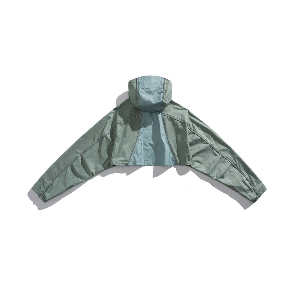 Back view of a sage green hooded cape jacket with wide sleeves and a contrasting center back panel.