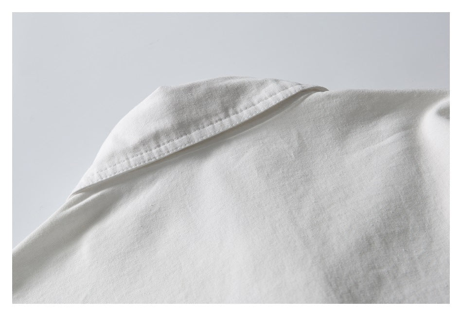 Close-up of the collar and shoulder seam on a white garment.