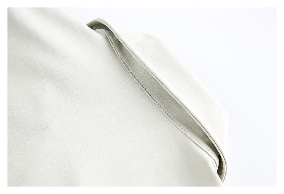 Close-up of a folded white garment edge with parallel stitching.