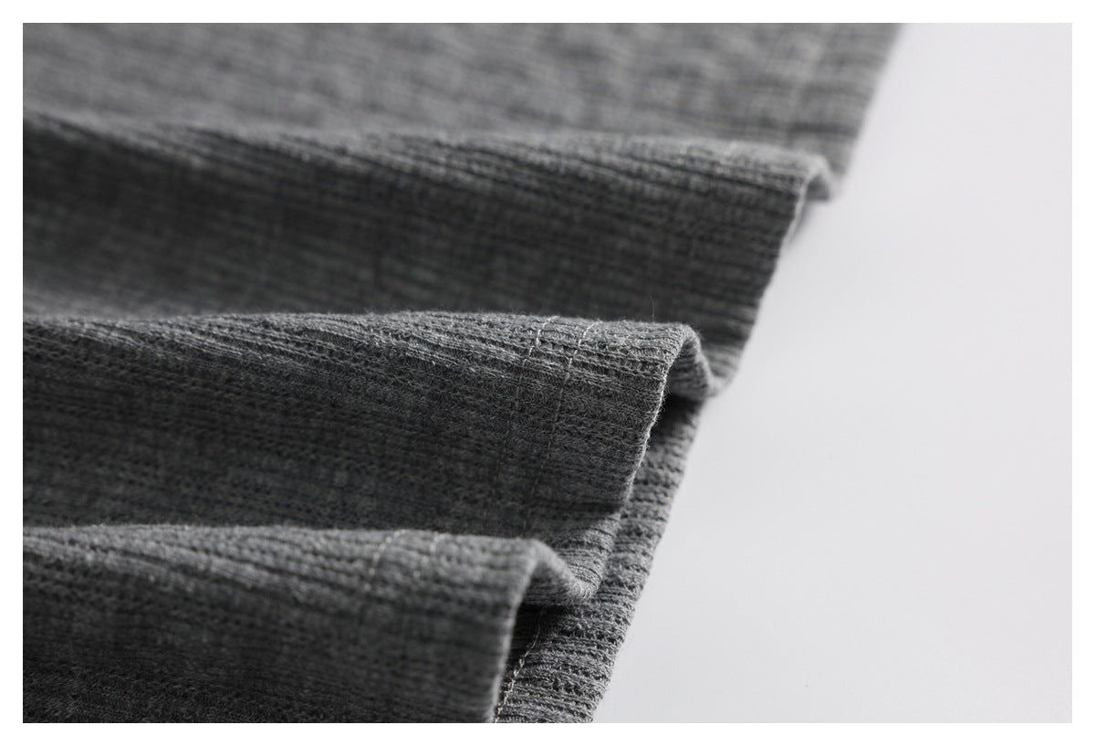 Close-up of folded, stitched edges on gray ribbed knit fabric.