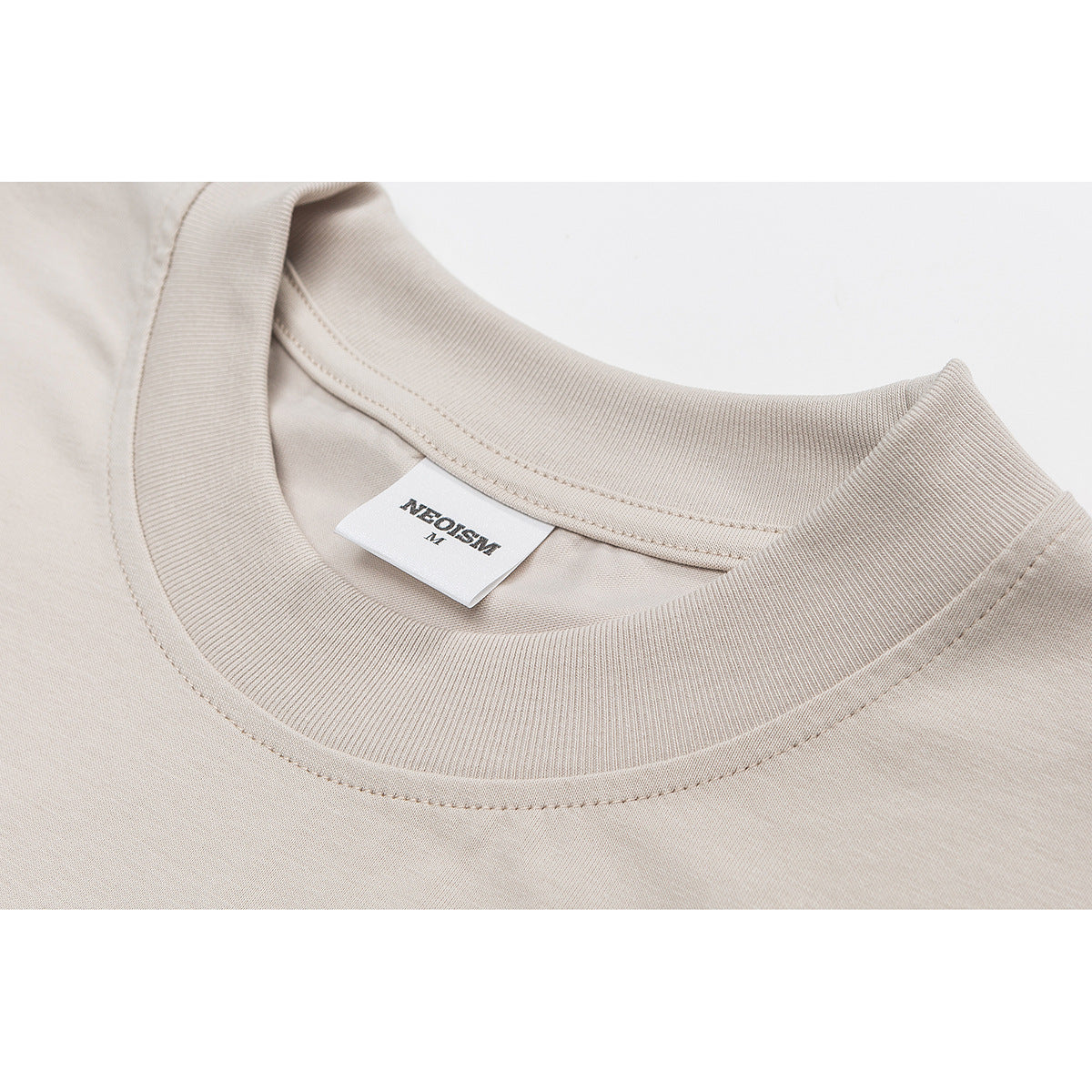 Close-up of a beige T-shirt’s ribbed crew neck and inner brand label.