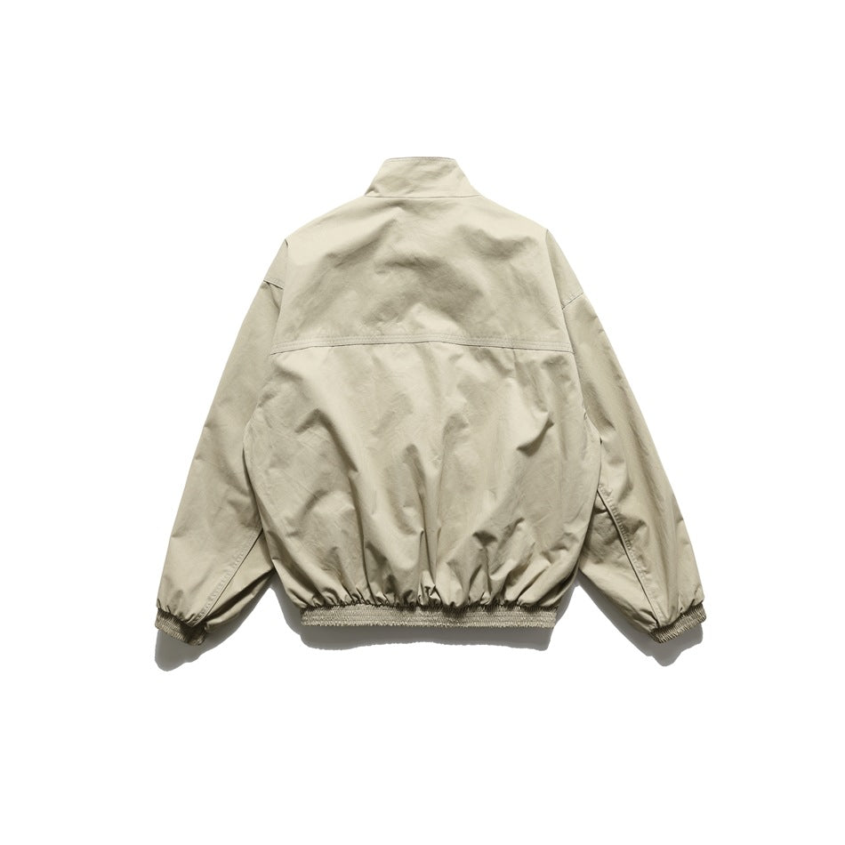 Back view of khaki stand-collar jacket showing shoulder yoke seam and elasticated hem and cuffs