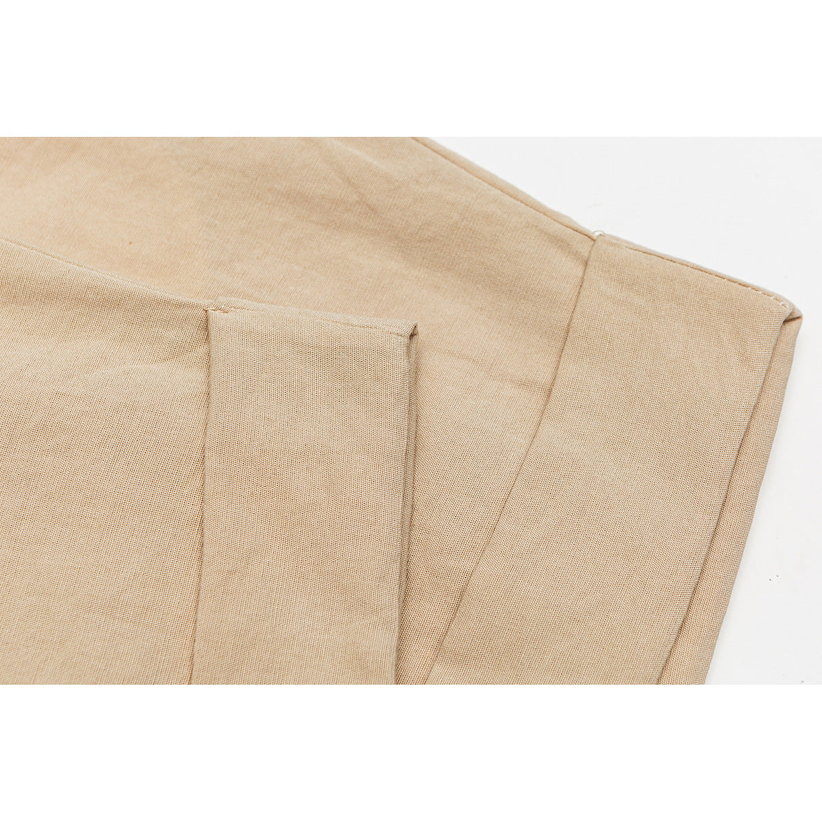 Close-up of tan shorts showing the fabric, seams, and folded cuff.