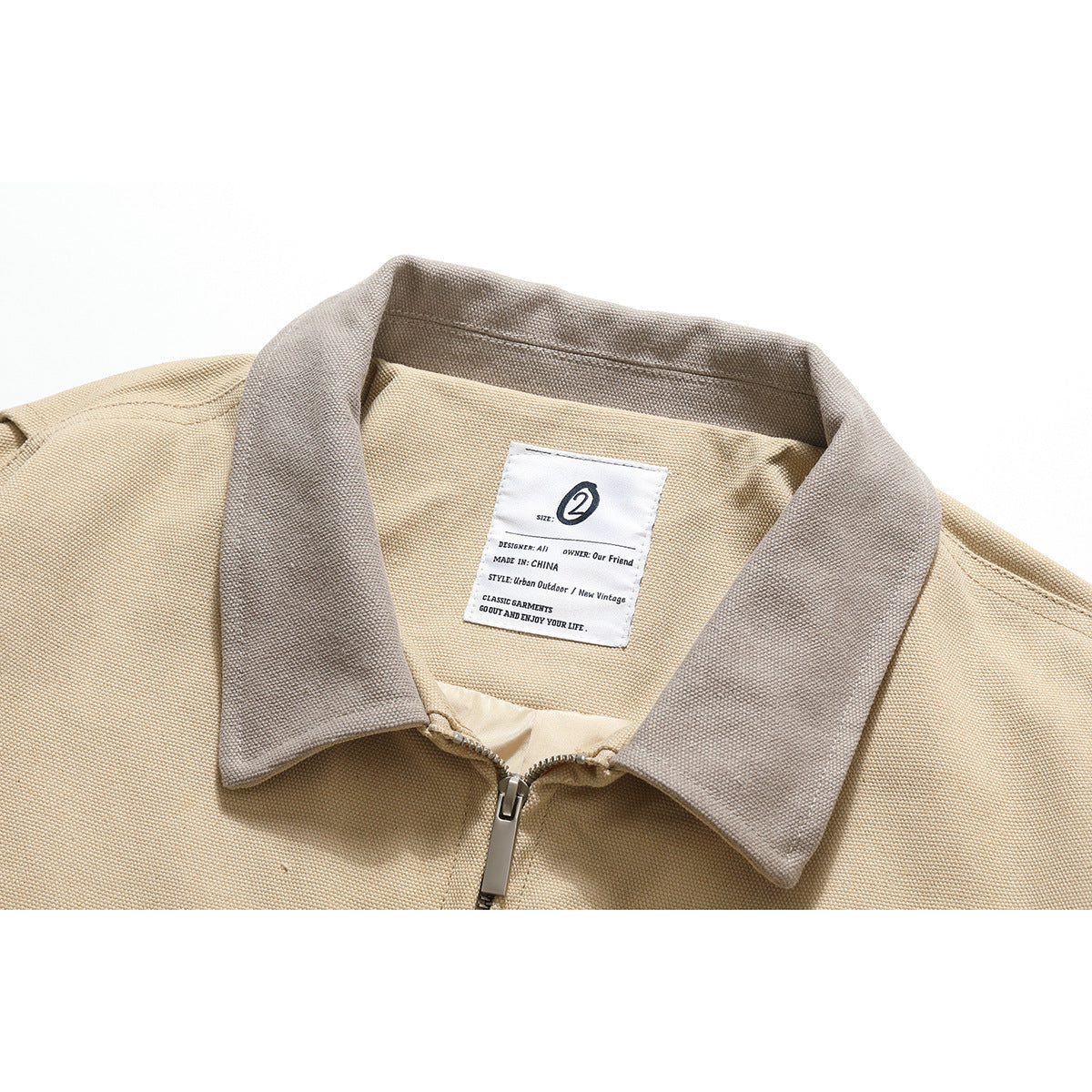Close-up of a beige jacket's taupe collar, front zipper, and sewn neck label.