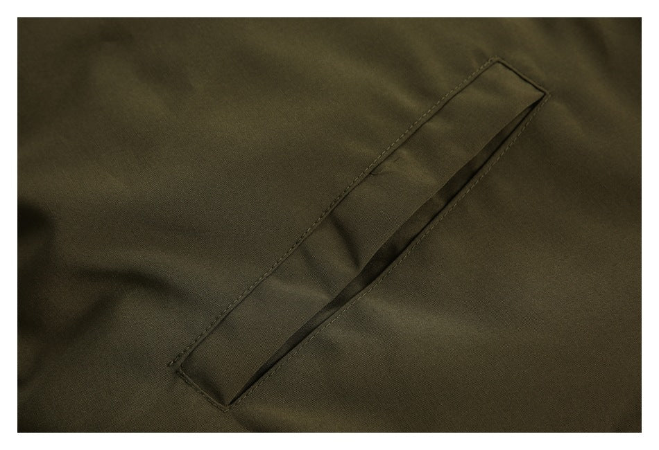 Close-up of a narrow welt pocket on an olive jacket.