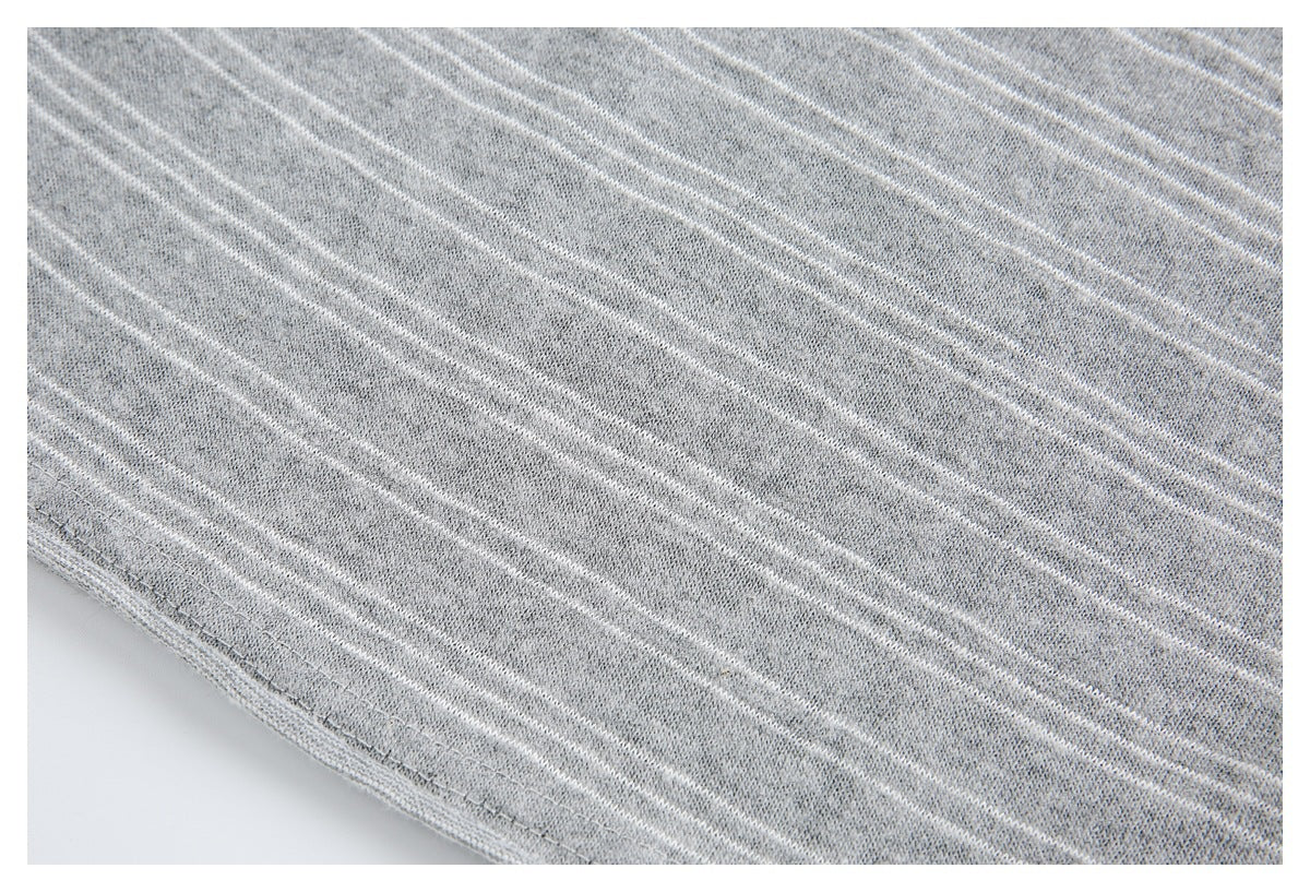 Close-up of gray knit fabric with thin white stripes and a stitched edge.