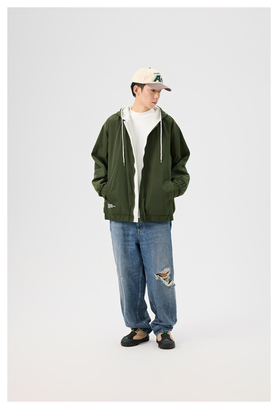 Full-length model wearing an open dark green hooded jacket over a white shirt and jeans.