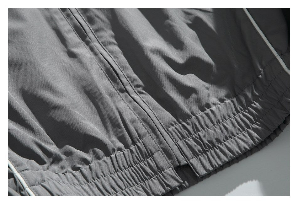 Close-up of charcoal pants showing a front zipper and gathered elastic waistband.
