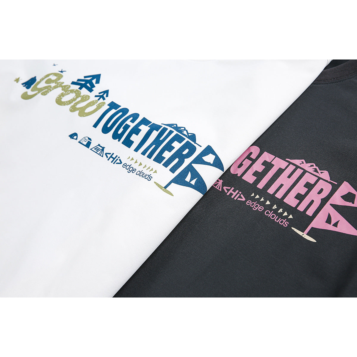 Close-up of white and charcoal T-shirts with colorful “Grow Together” graphic prints.