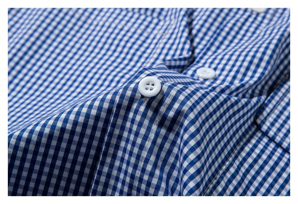 Close-up of white buttons on the placket of a blue-and-white gingham shirt.