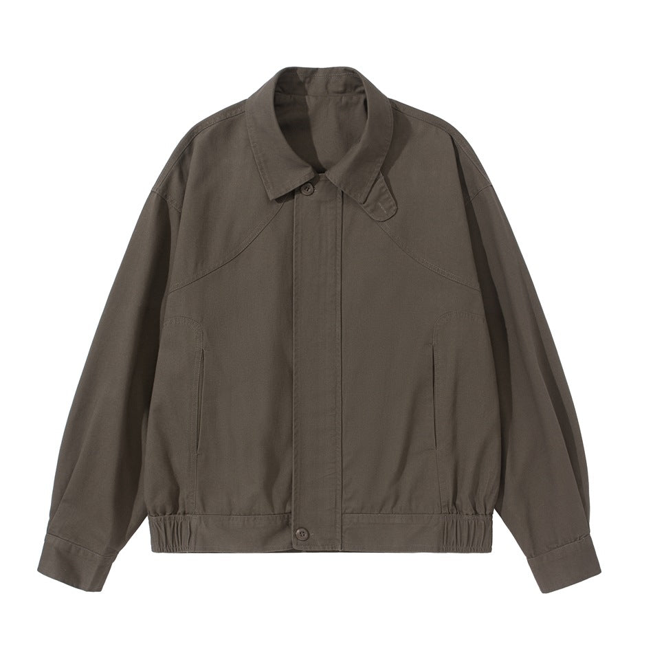 Brown collared short jacket with curved yoke seams, slanted pockets and elastic hem, front flat lay