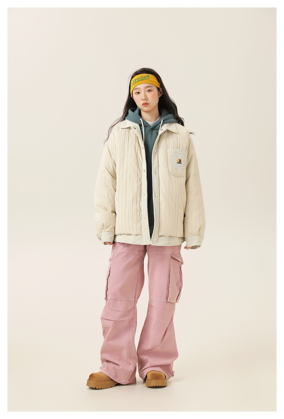 Model wearing off-white quilted shirt jacket over a teal hoodie with pink cargo pants, front view