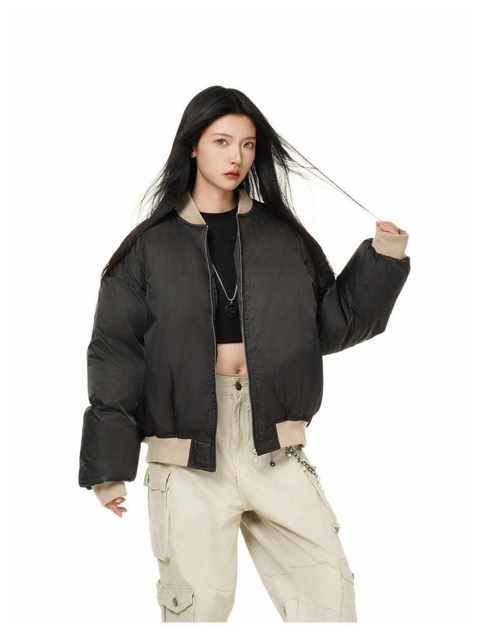 Model wearing an open black bomber jacket with beige ribbed trim over a black top and cargo pants