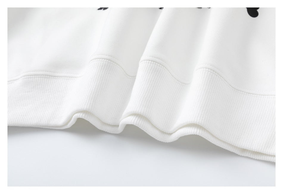 Close-up of the white garment's wide ribbed bottom hem and stitched seam.