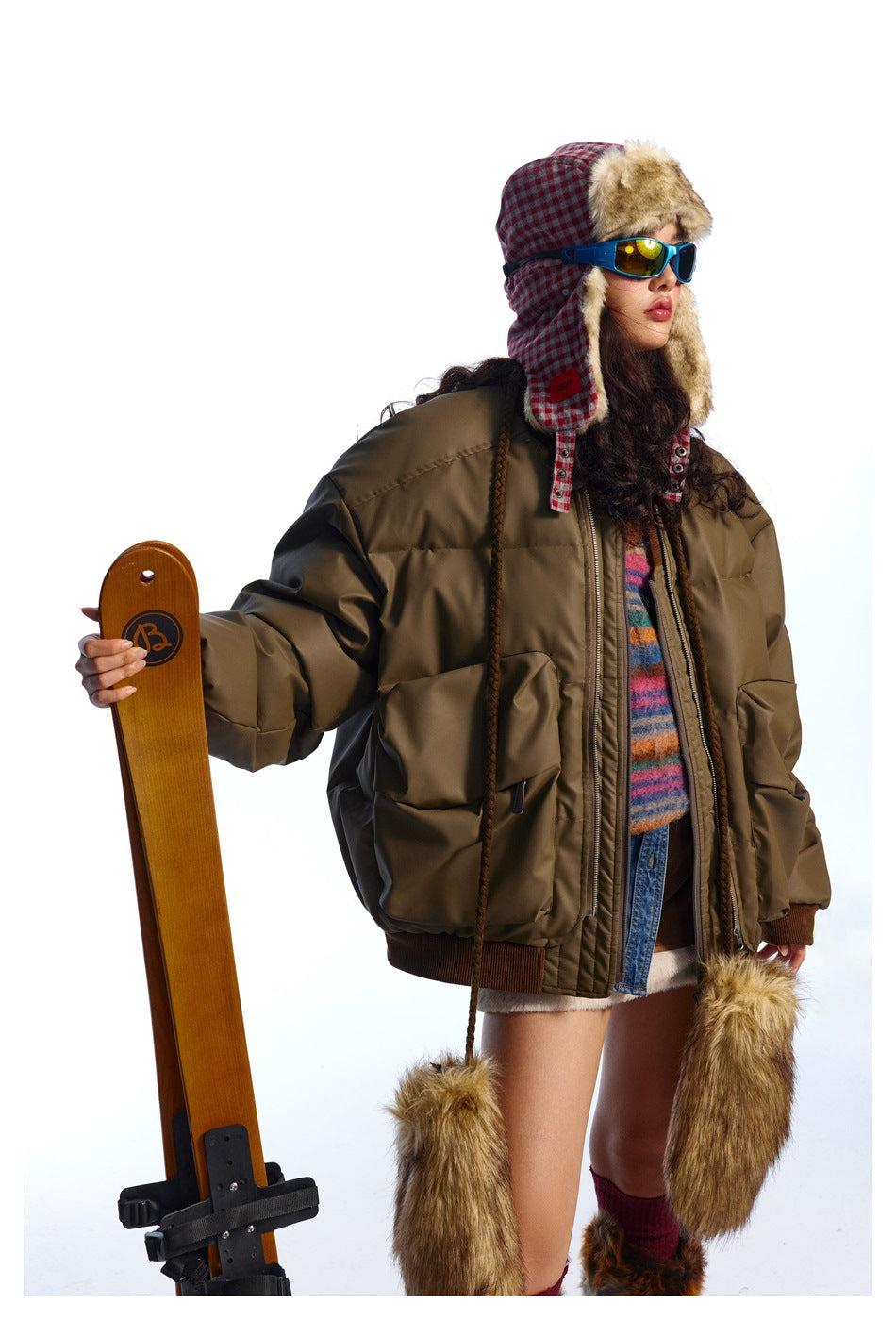 Model wearing an oversized olive-brown padded bomber jacket with large pockets and ribbed trim, shown from the front.