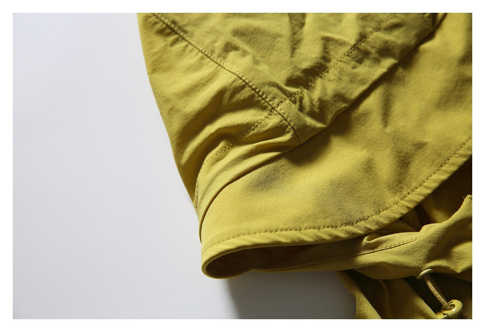 Close-up of the mustard vest's hood, showing stitched seams and the hood edge.