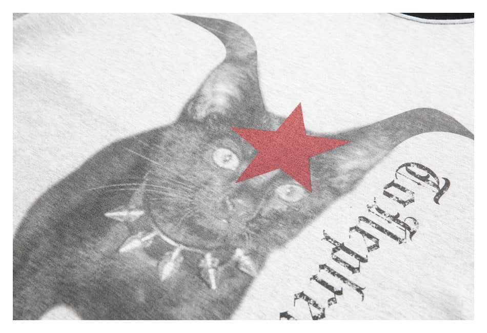 Close-up of a heather gray shirt graphic showing a black cat, red star, and distressed lettering.
