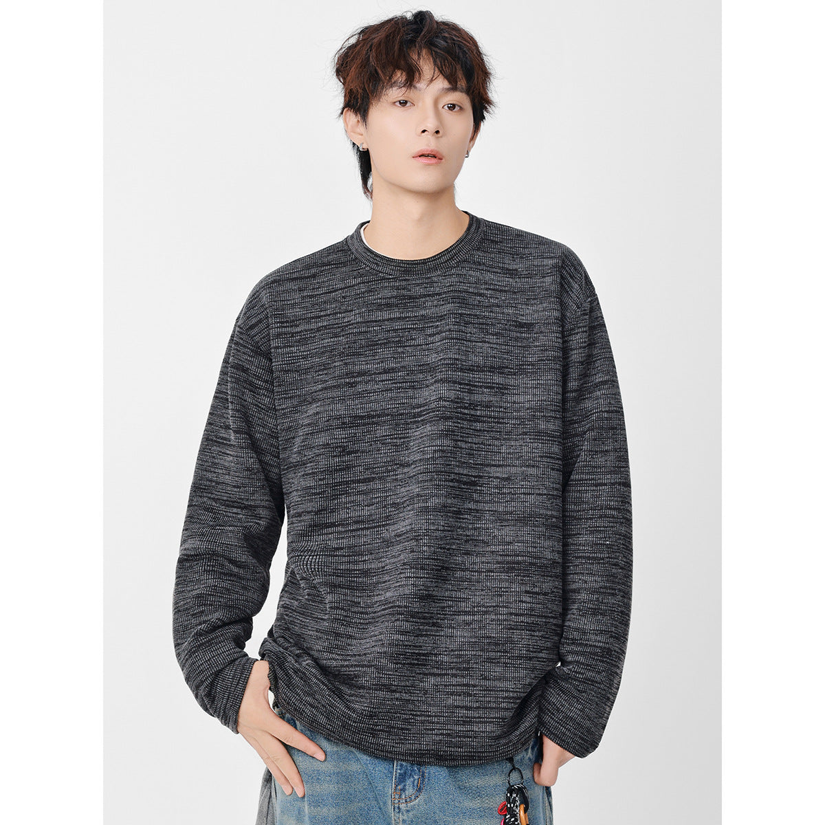 Close view of a model wearing a charcoal marled crewneck sweatshirt with a ribbed neckline.