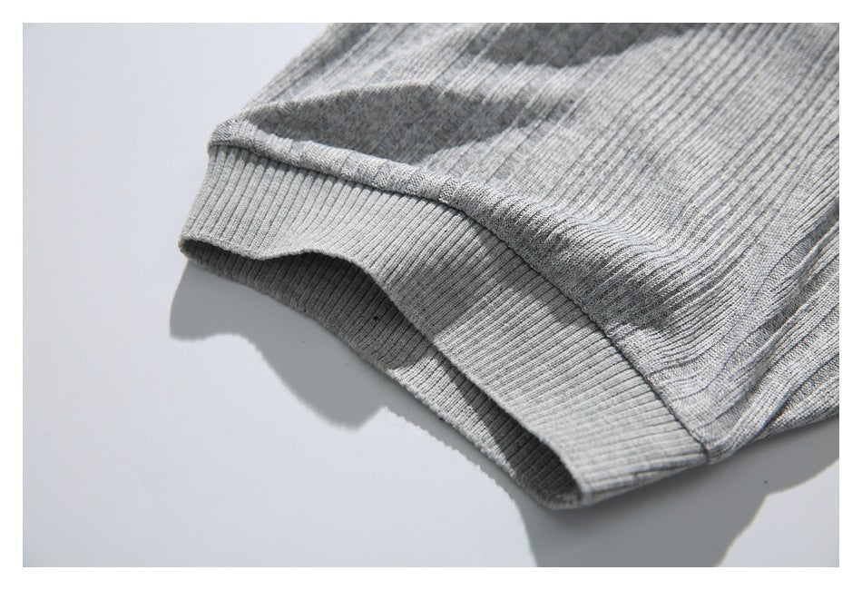 Close-up of the gray polo shirt's ribbed sleeve cuff and adjoining seam.