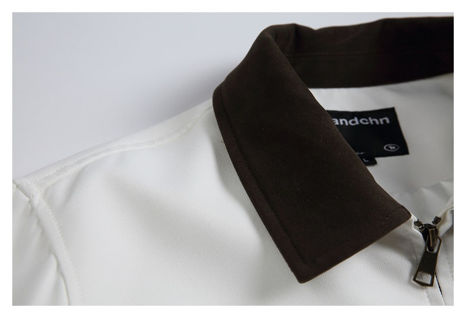 Angled close-up of a white garment's dark brown collar and shoulder seam.