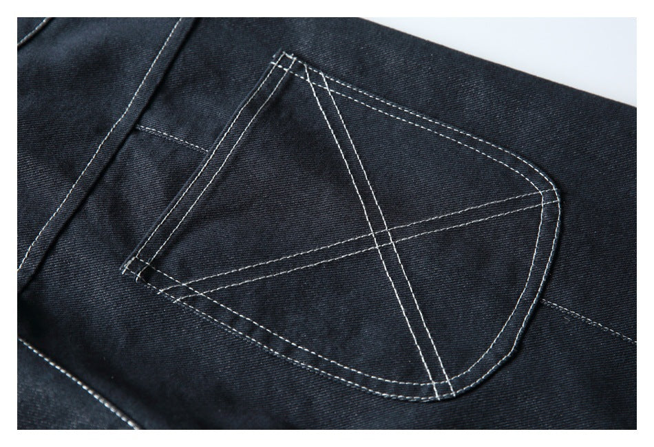 Close-up of a dark denim back pocket with geometric contrast topstitching.